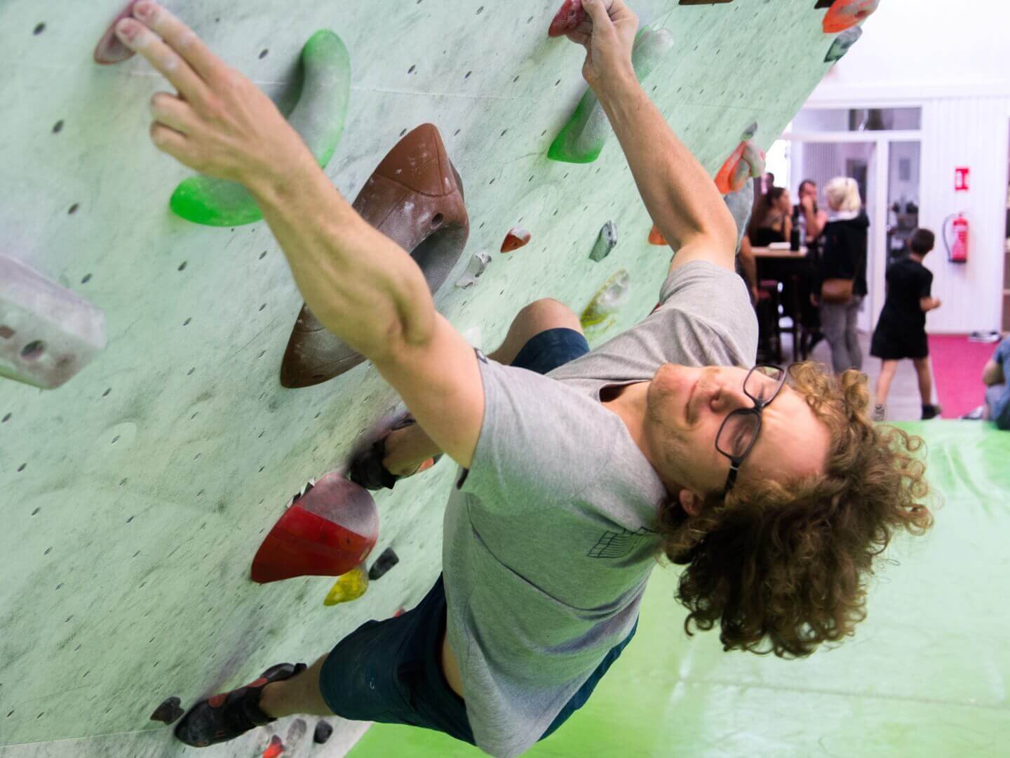 Person bouldert in der Kletterhalle