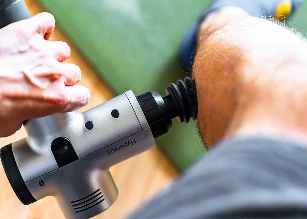 Massagepistole an der Wade