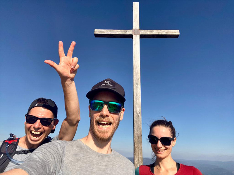 Bergfreunde posieren am Gipfelkreuz.