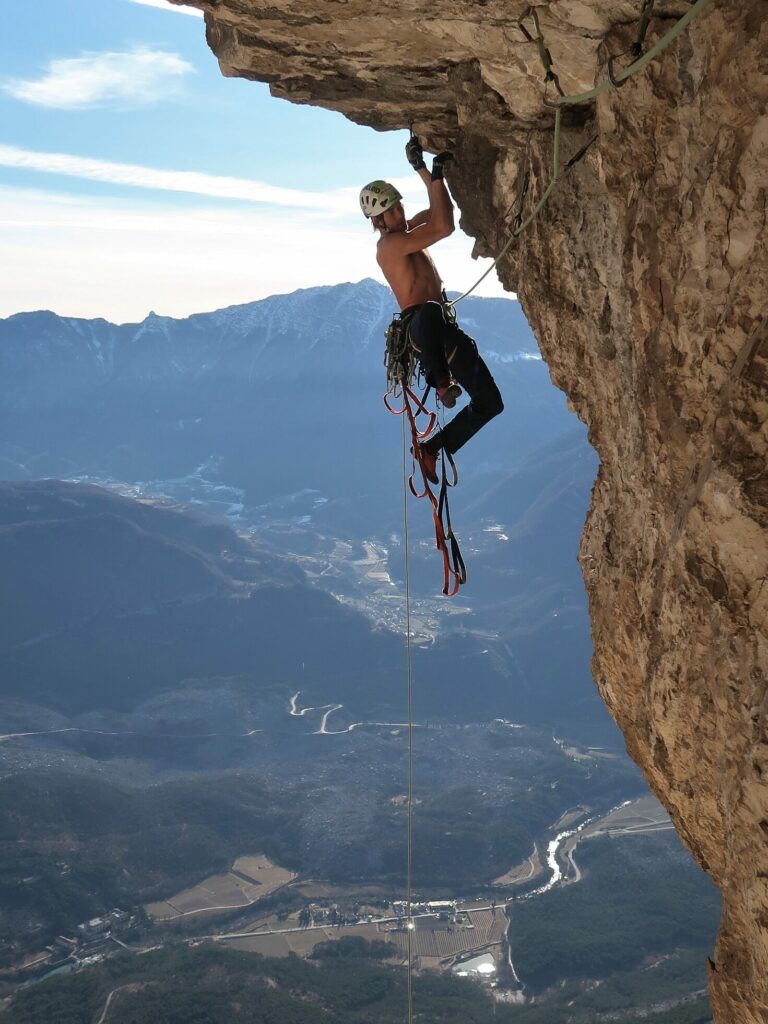 Mann klettert an einem Felsen