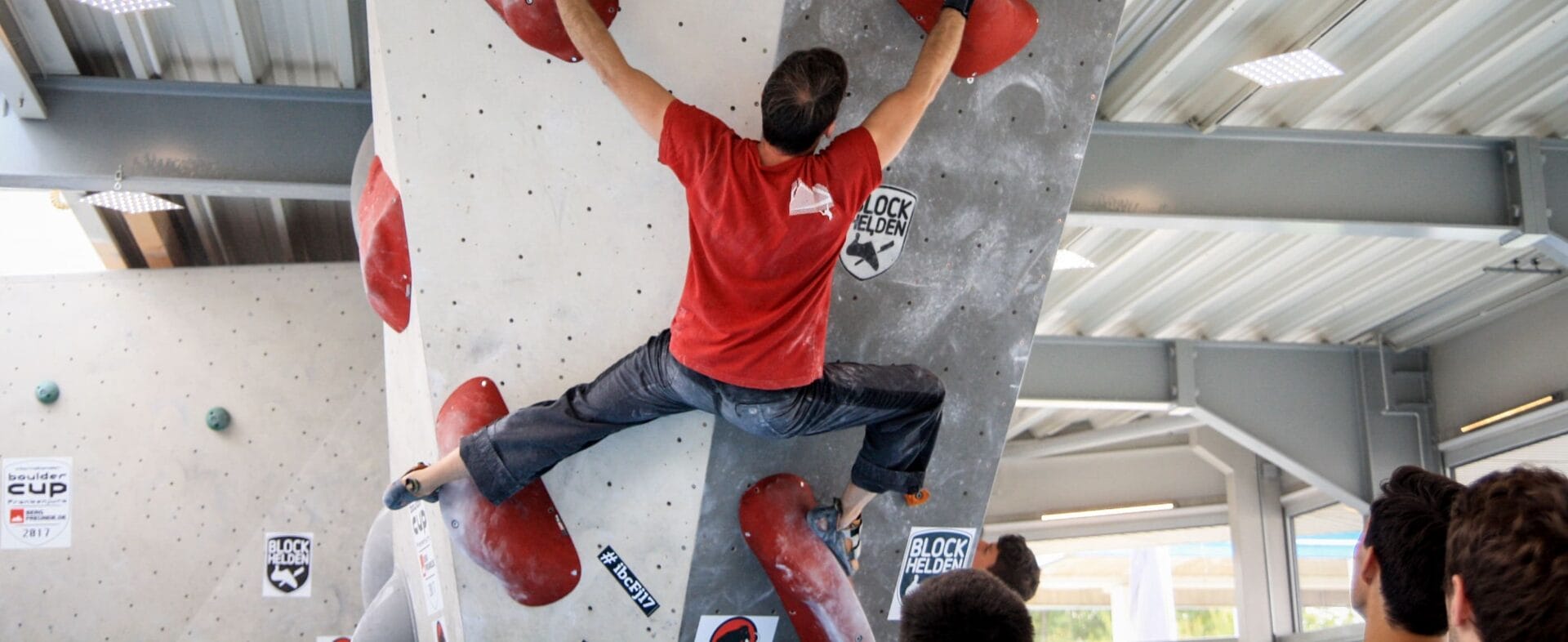 Gespreizter Mann an der Boulderwand